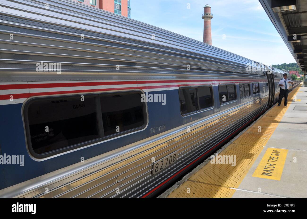 YONKERS, NUEVA YORK: Conductor en la plataforma de la estación de tren de  Yonkers de pie junto a un tren de Amtrak enroute a NYC Fotografía de stock  - Alamy