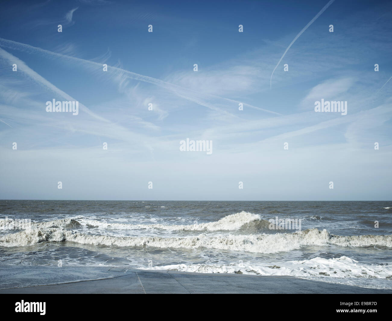 Mar scape con ondas y jet blue sky senderos en el paseo marítimo de Blackpool Fylde Coast, el noroeste de Inglaterra. Foto de stock