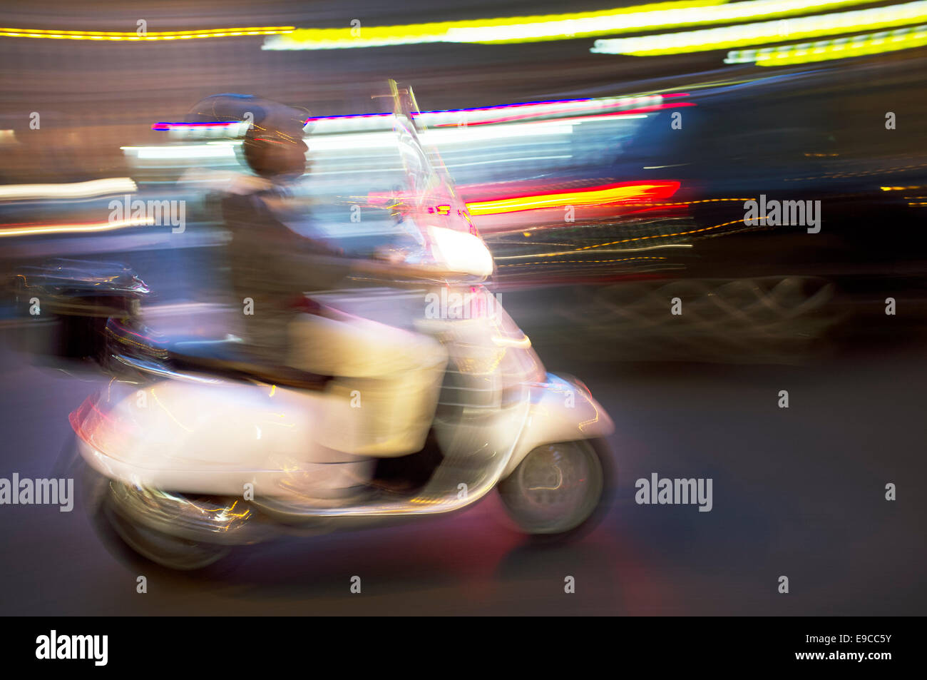 Imagen borrosa abstracta de un scooter de conducir de noche. Foto de stock
