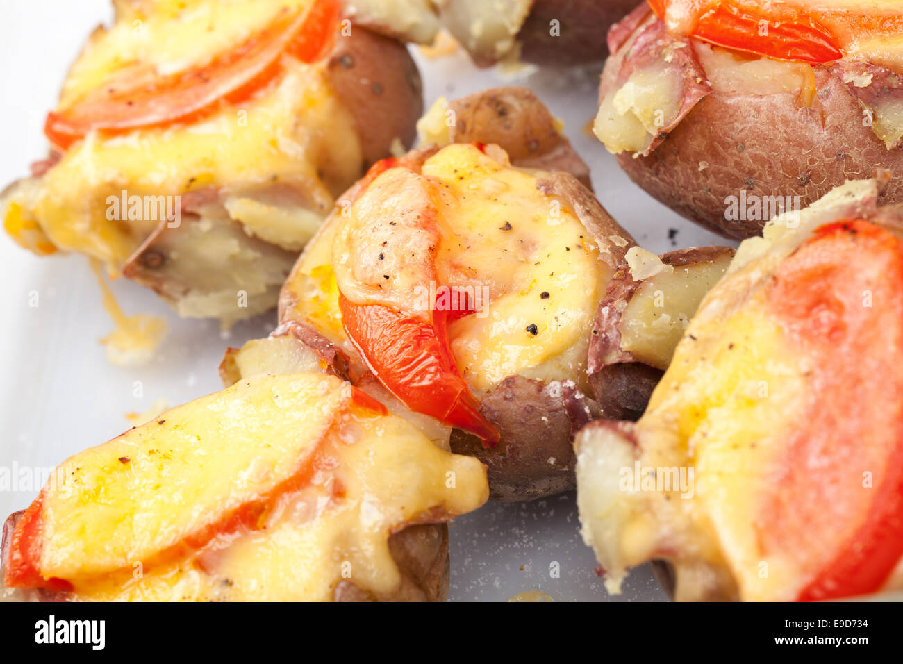 Papas horneadas caseras con tomate, tocino y queso. Fotografía macro con el enfoque selectivo Foto de stock