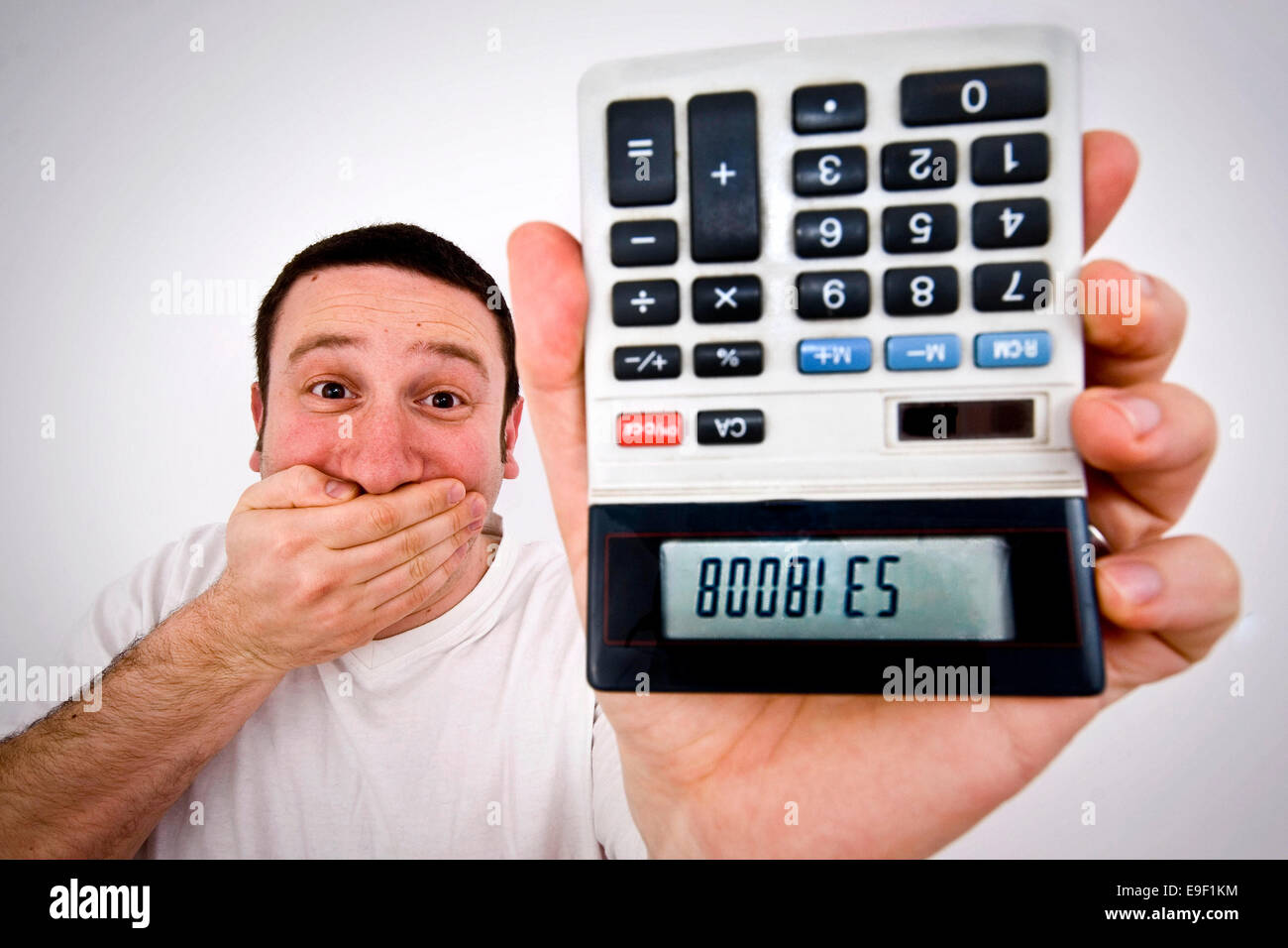 Un hombre sostiene una calculadora boca abajo, con las palabras