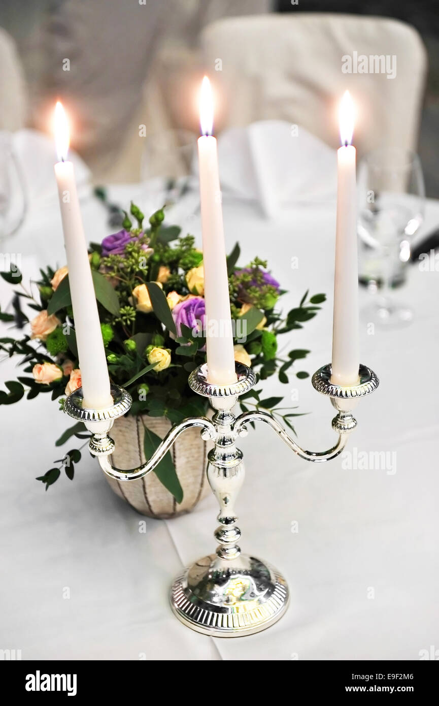 Candelabro con velas y arreglos florales en la elegante cena Foto de stock