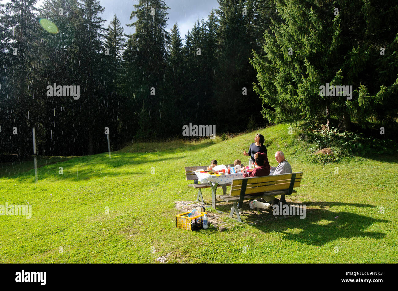 Lloviendo sobre un picnic familiar en un bosque en los Dolomitas, Italia Foto de stock
