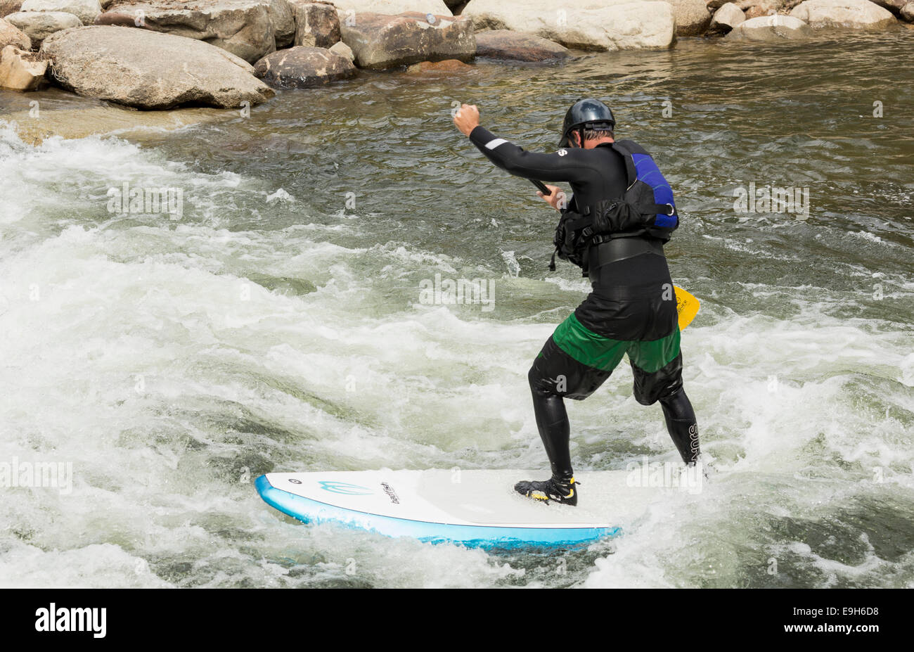 Hombre en un stand-up paddle board en los rápidos del Río Arkansas en Buena Vista, Colorado, EE.UU. Foto de stock