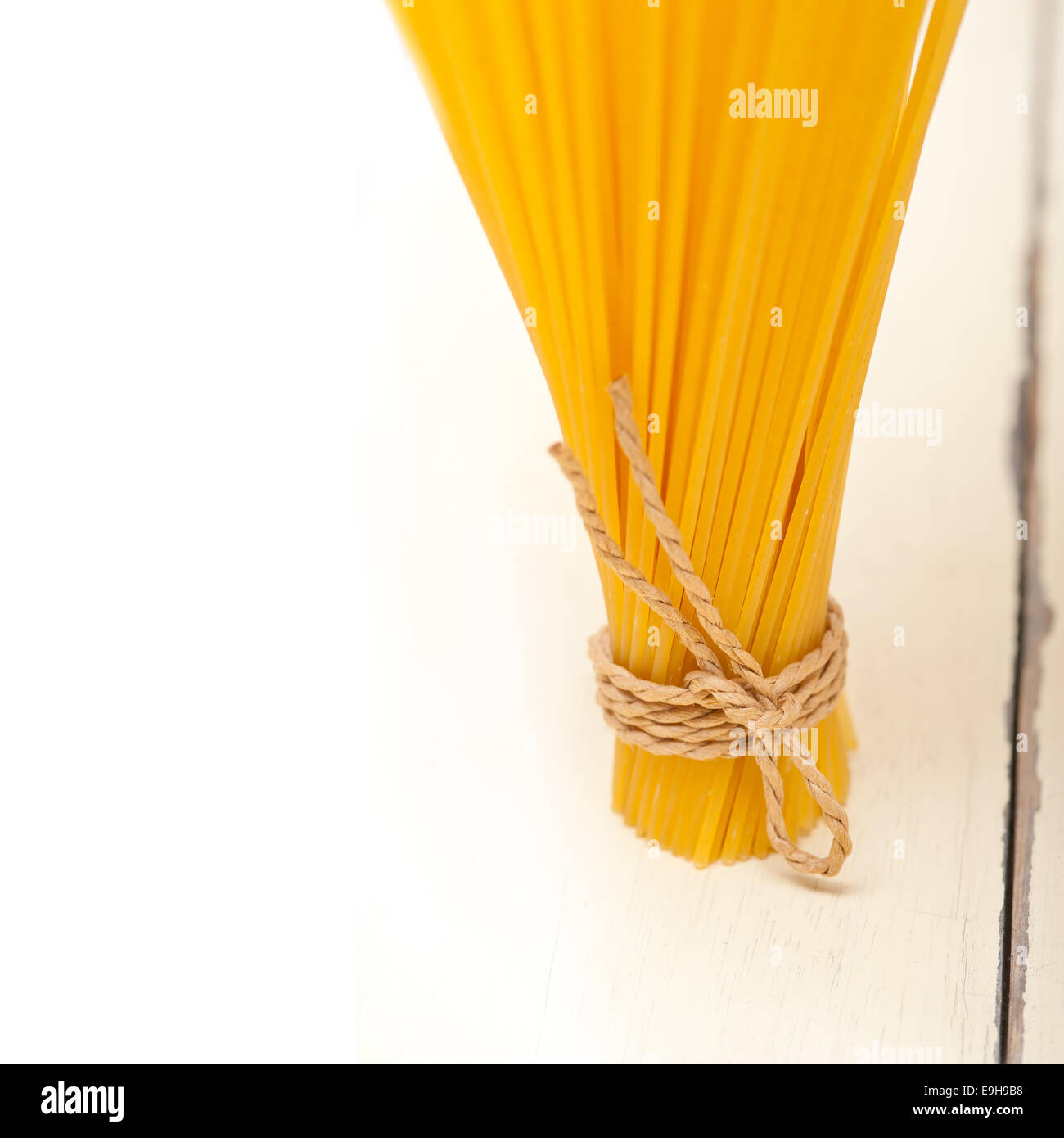 Las pastas italianas espaguetis atados con una cuerda en una tabla rústica Foto de stock