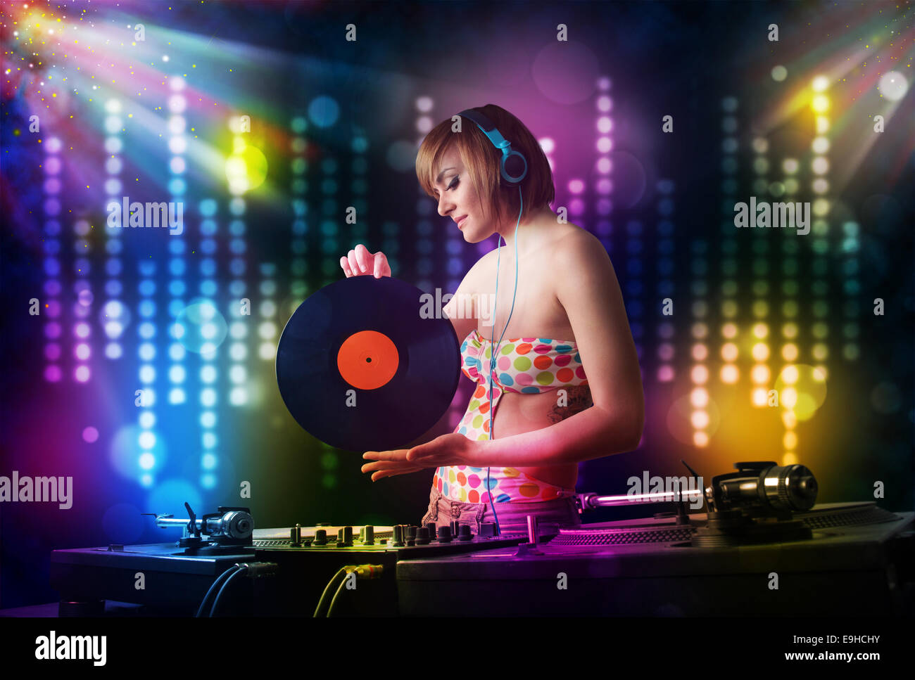 Chica Dj tocando canciones en una discoteca con espectáculo de luces  Fotografía de stock - Alamy