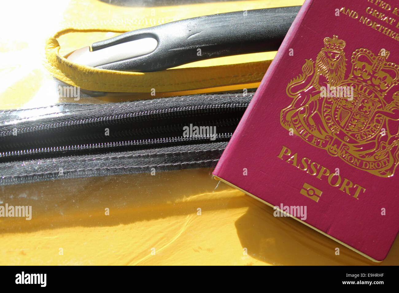 Distintivo amarillo maleta con un pasaporte británico rojos simbolizando la marcha después de Brexit, la inmigración en el Reino Unido y los titulares de un pasaporte británico Foto de stock