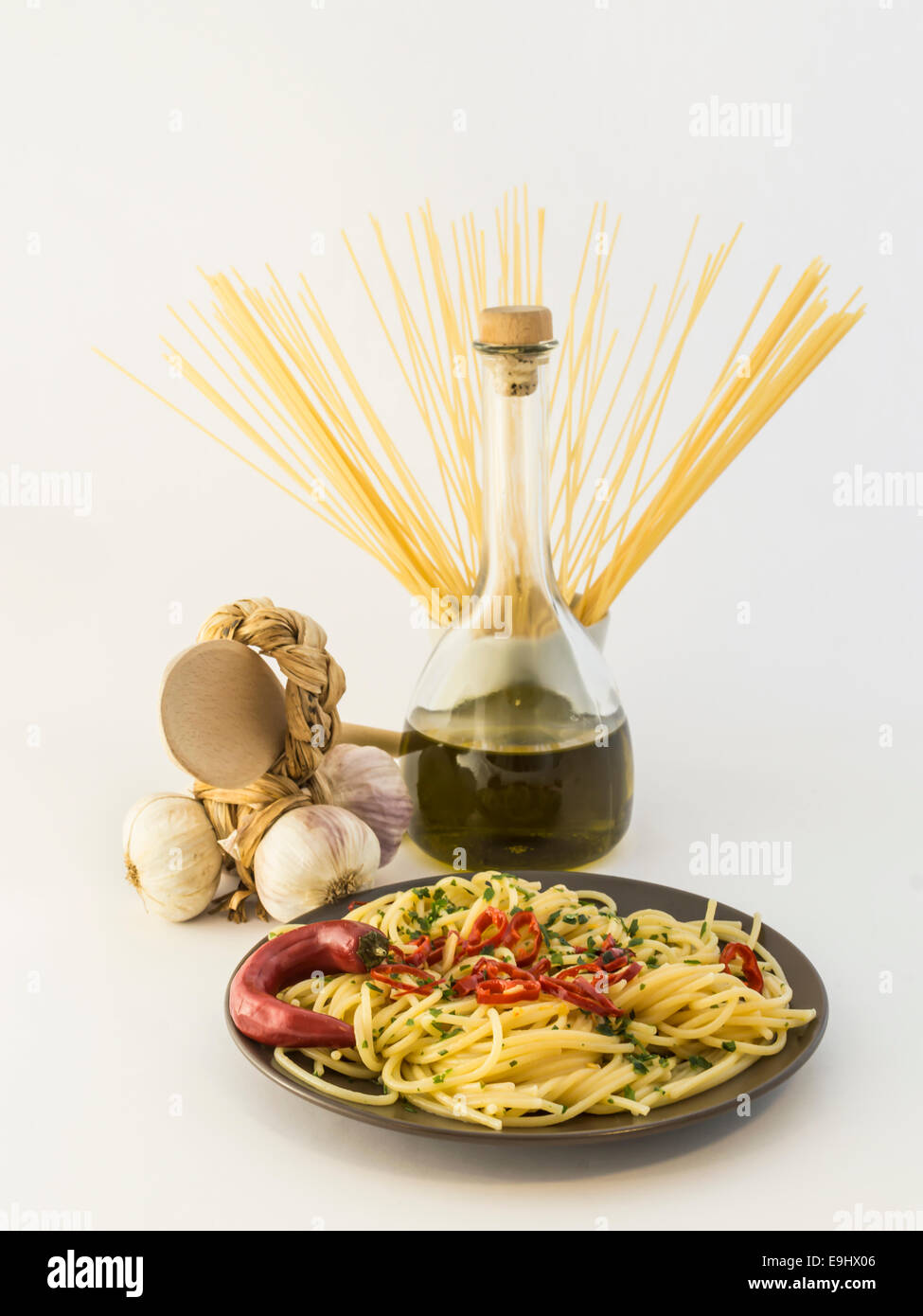 Plato de espaguetis con ajo, aceite de oliva, ají sobre fondo blanco. Foto de stock