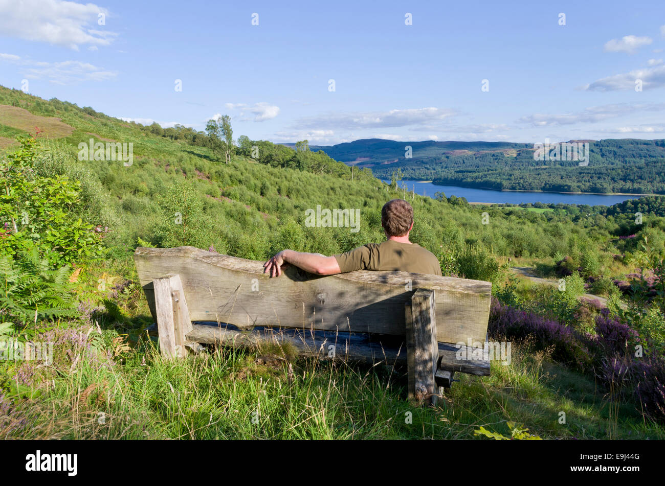 Hombre caucásico sentado en un banco de Lendrick Hill, Glen Finglas, Trossachs, Stirlingshire, Escocia, Reino Unido modelo liberado Foto de stock