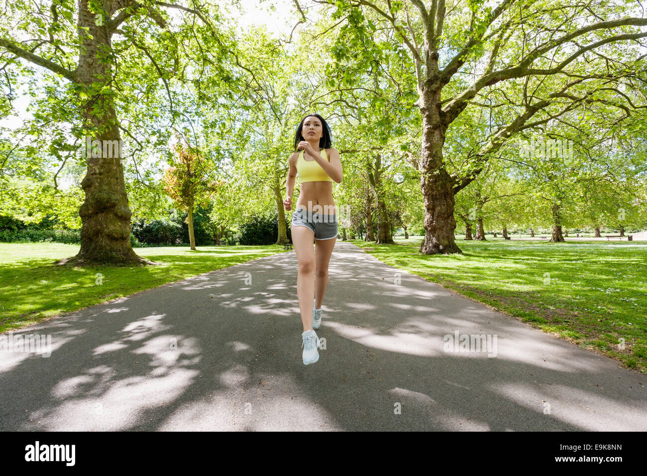 Longitud total de determinado colocar mujer jogging en el parque Foto de stock
