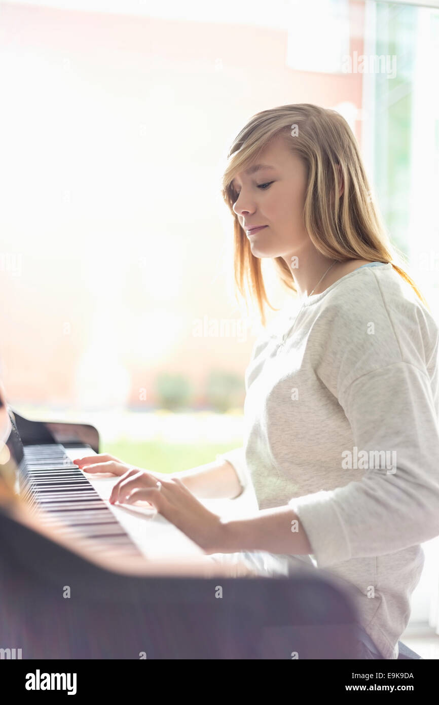 Adolescente tocando el piano en casa Foto de stock