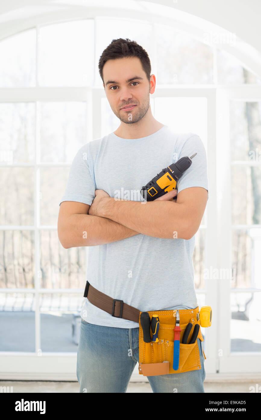 Retrato del hombre que confía con taladro de mano en casa nueva Foto de stock