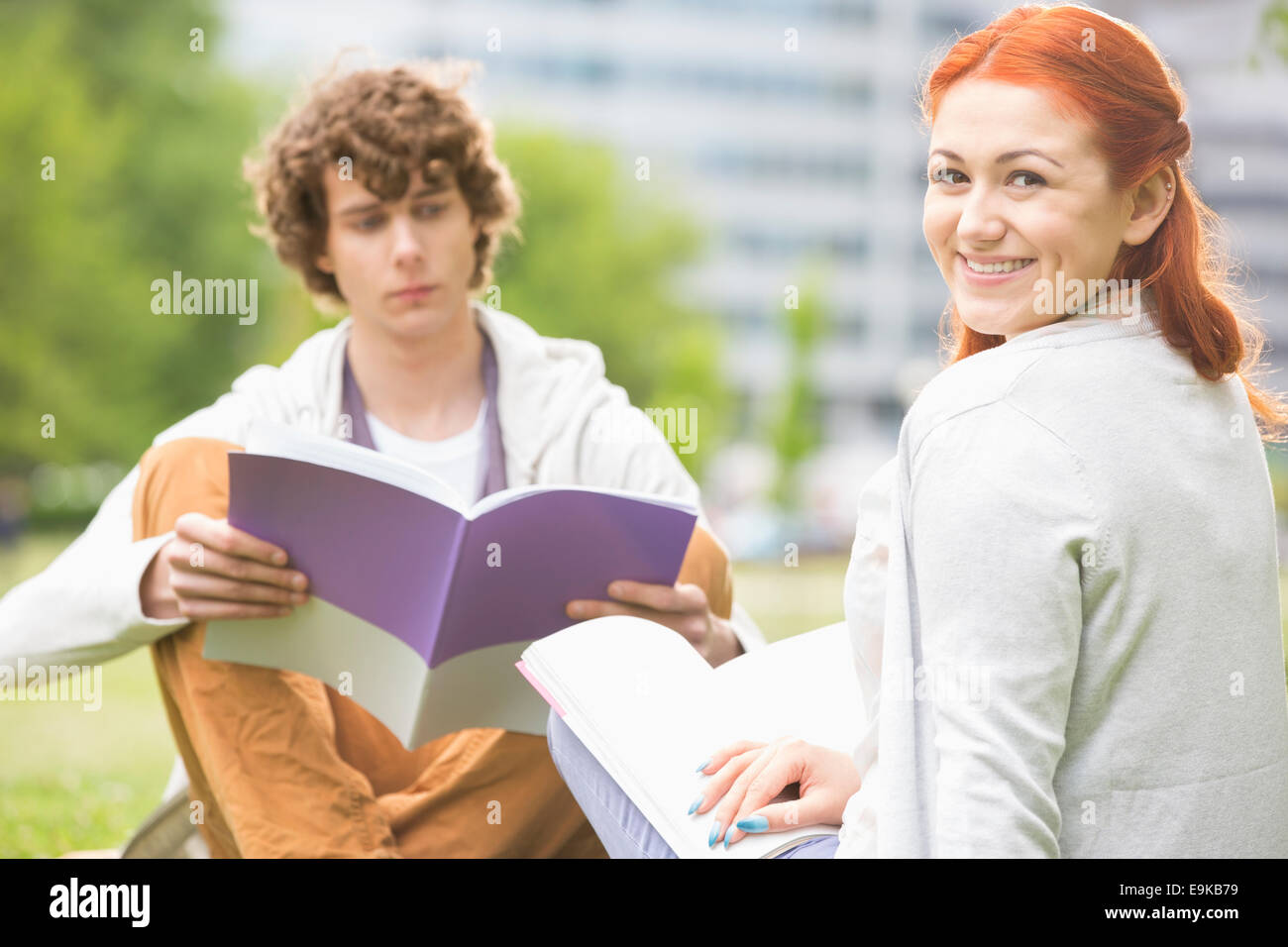 Retrato de mujer joven feliz con amigo masculino estudiando en campus universitario Foto de stock