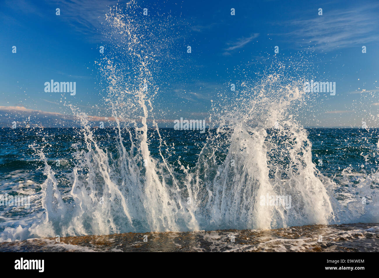Las olas del mar las salpicaduras de la roca en la playa Foto de stock