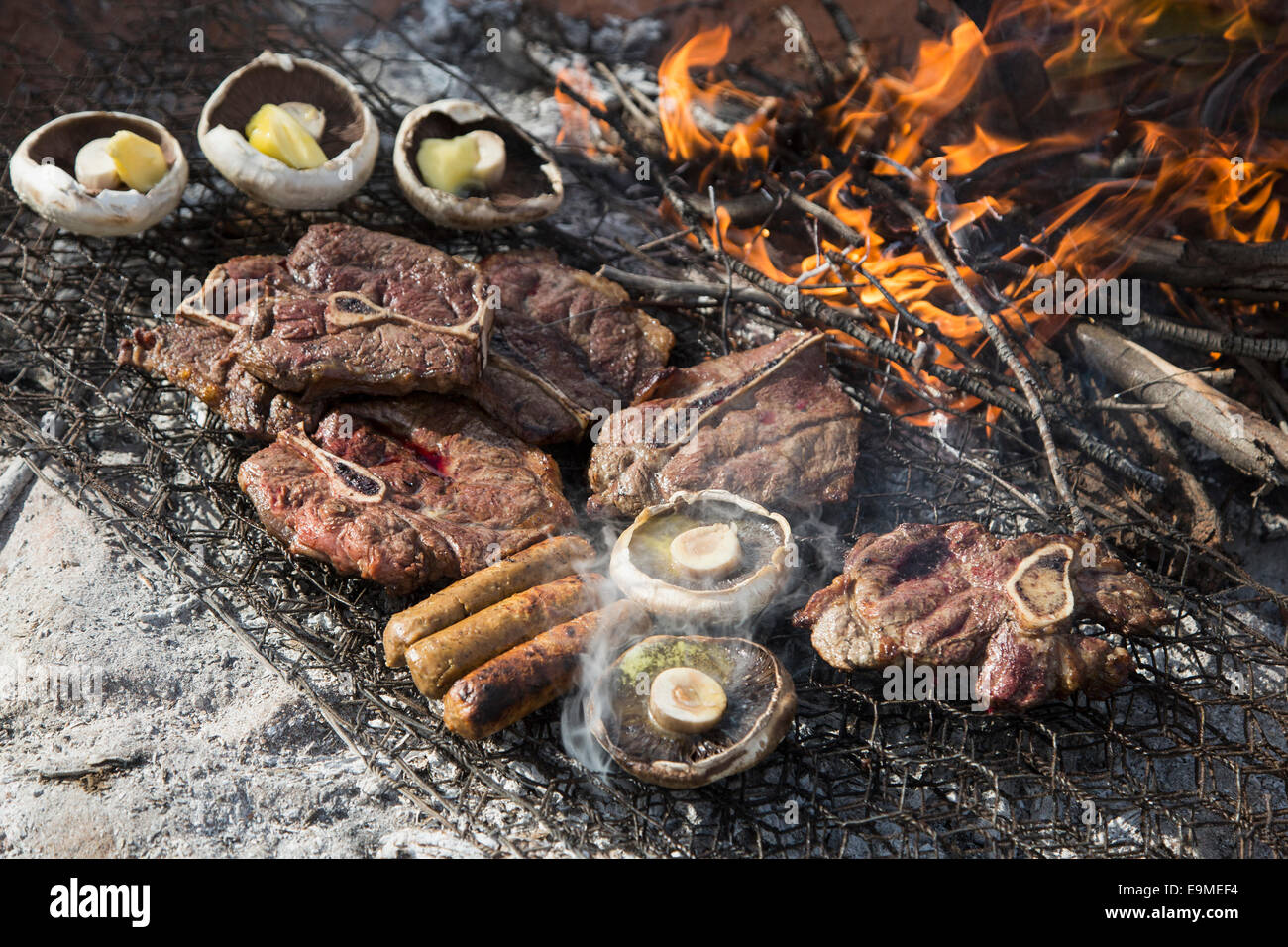 Un alto ángulo de visualización de carne y setas están cocinando Foto de stock