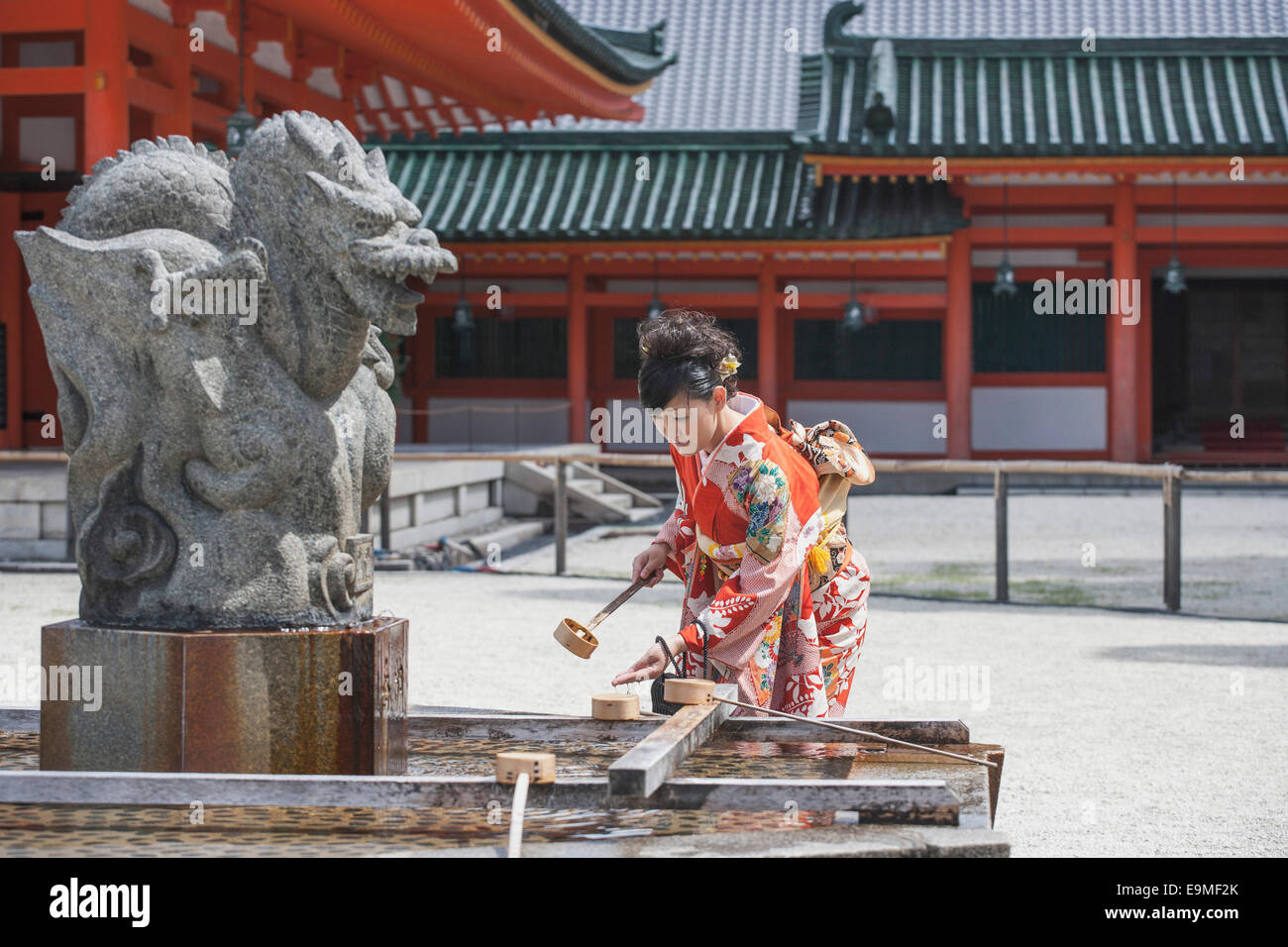 Mujer adulta media mano lavado contra el templo Foto de stock