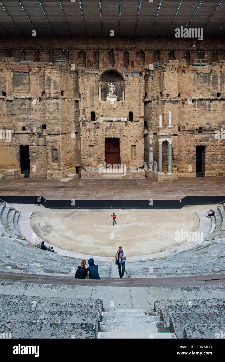 Los turistas en el auditorio y romano de la scaenae frons Théâtre Antique d'Orange / Teatro Antiguo de Orange, Vaucluse, Francia Foto de stock