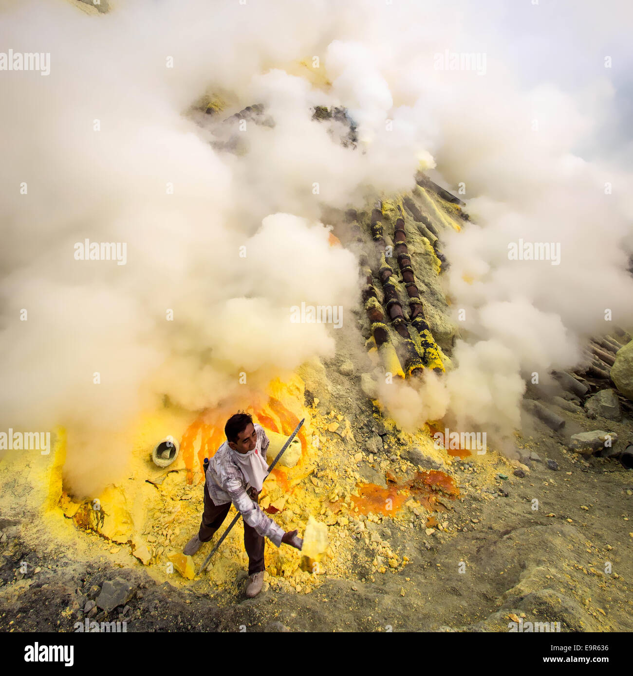 La minera de azufre recolectando azufre en el volcán Kawah Ijen en Java Oriental, Indonesia. Foto de stock
