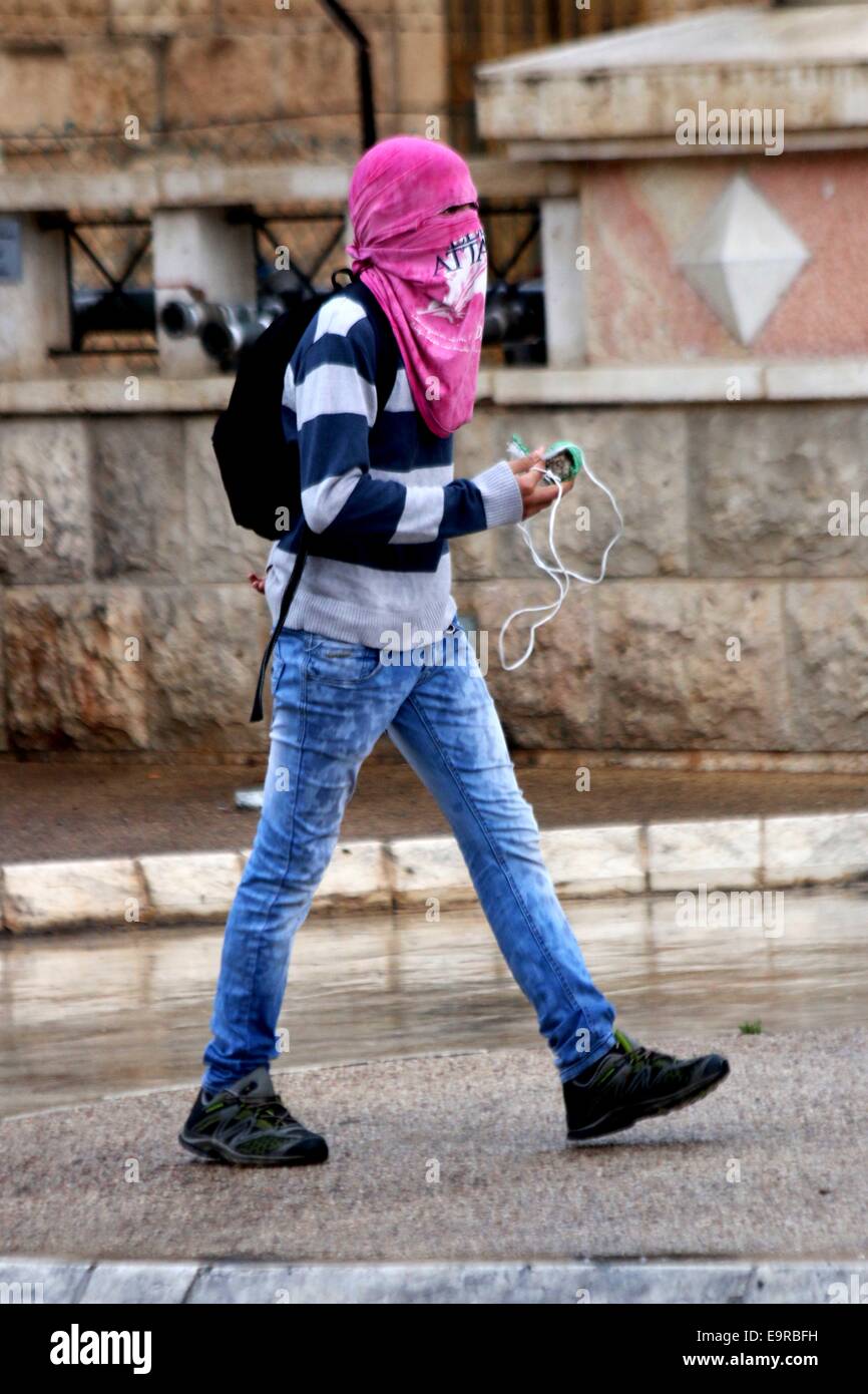Un joven palestino enmascarado posee un tirachinas casero. Los jóvenes  palestinos se reunieron en las calles de Belén, en Cisjordania para  protestar en contra de las restricciones a los musulmanes palestinos en