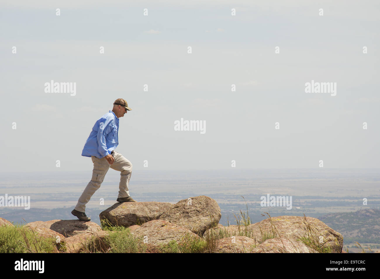 Un varón de mediana edad caminando en la cima de una montaña Foto de stock