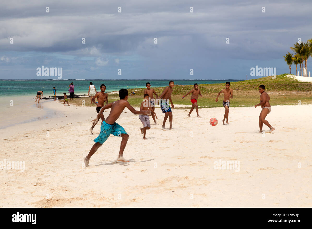Los niños y adolescentes de Mauricio jugando al fútbol en la playa, Belle Mare Beach, en la costa oriental, Mauricio Foto de stock
