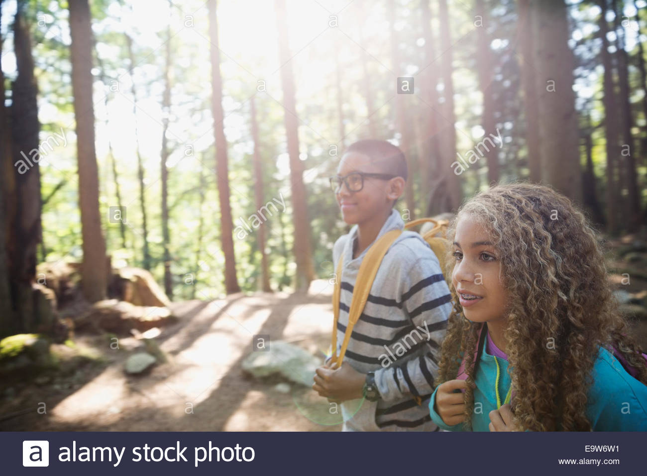 Chico y chica senderismo en sunny woods Foto de stock