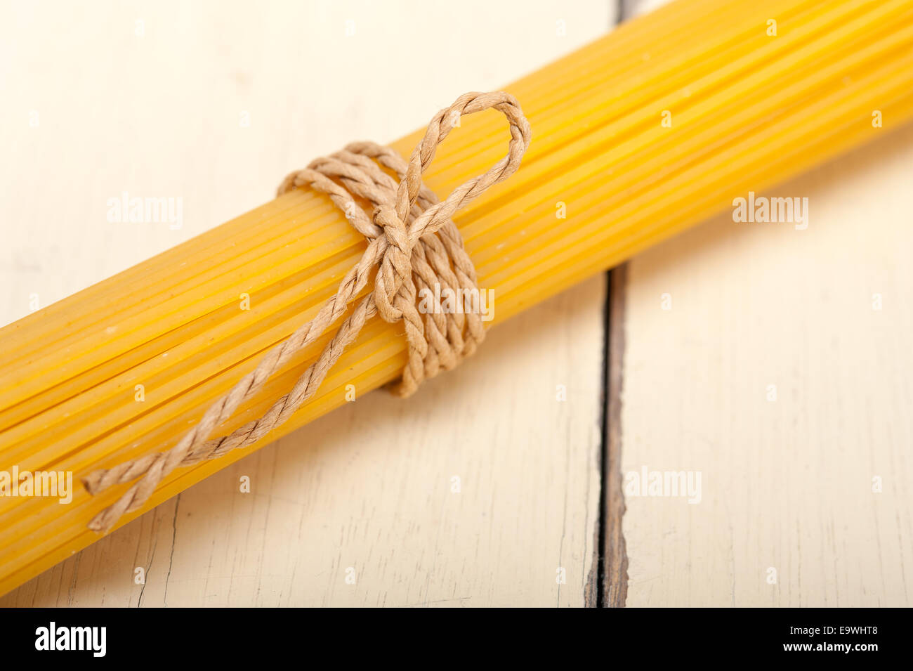 Las pastas italianas espaguetis atados con una cuerda en una tabla rústica Foto de stock