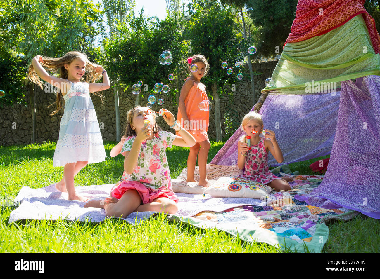 Las niñas soplando burbujas en verano garden party Foto de stock