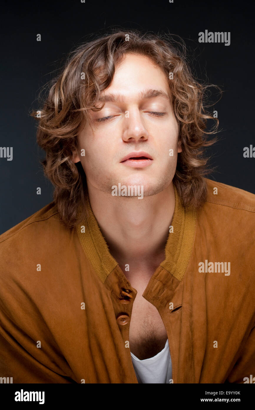 Retrato de un hombre joven con pelo marrón y los ojos cerrados Foto de stock
