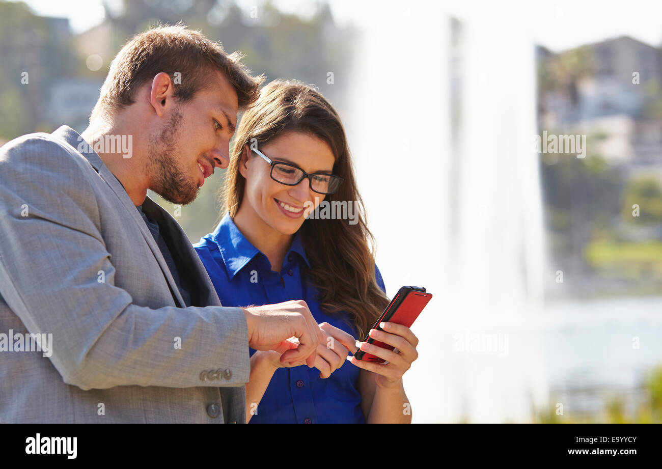 El empresario y la mujer utilizando el smartphone Foto de stock