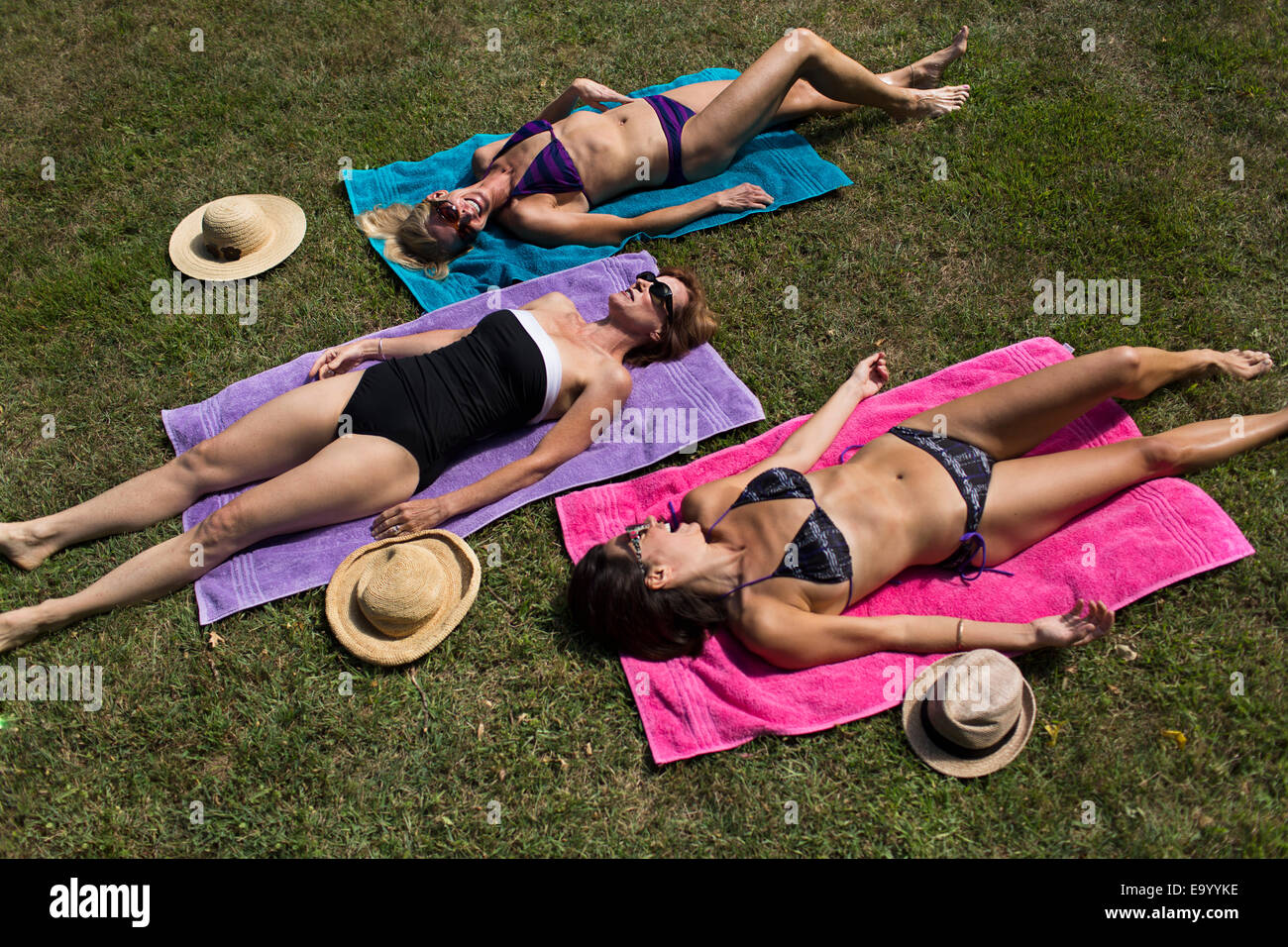 Tres mujeres maduras en traje de tomando el sol sobre césped Fotografía de stock - Alamy