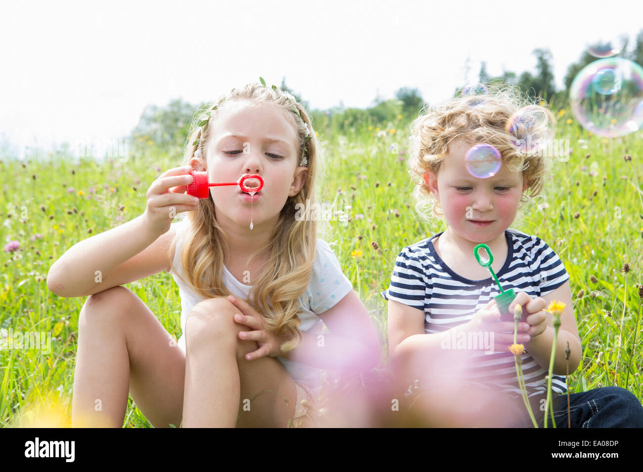 Dos niñas soplando burbujas Foto de stock