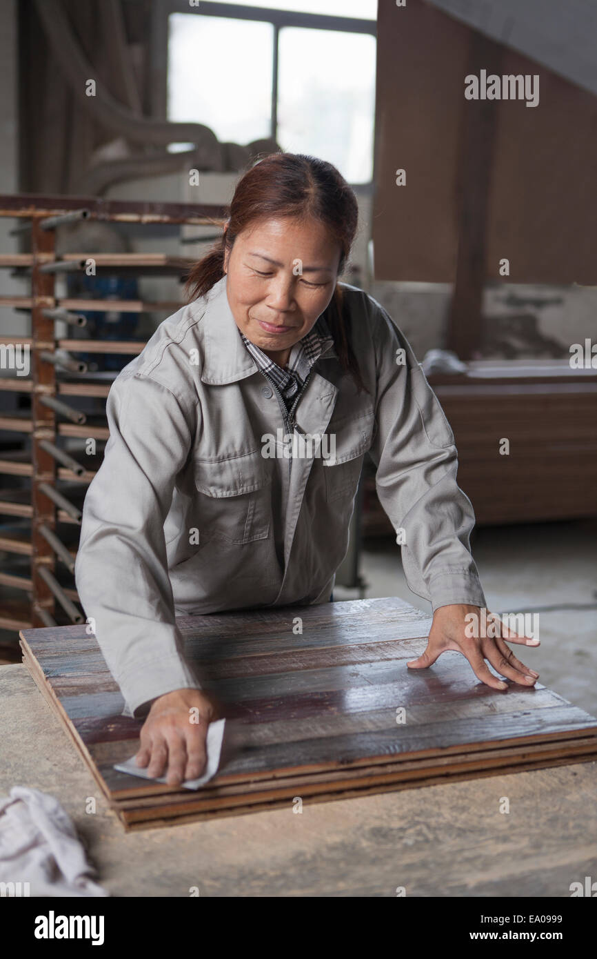 Carpenter suavizado de la superficie con papel de lija de madera en la fábrica, Jiangsu, China Foto de stock