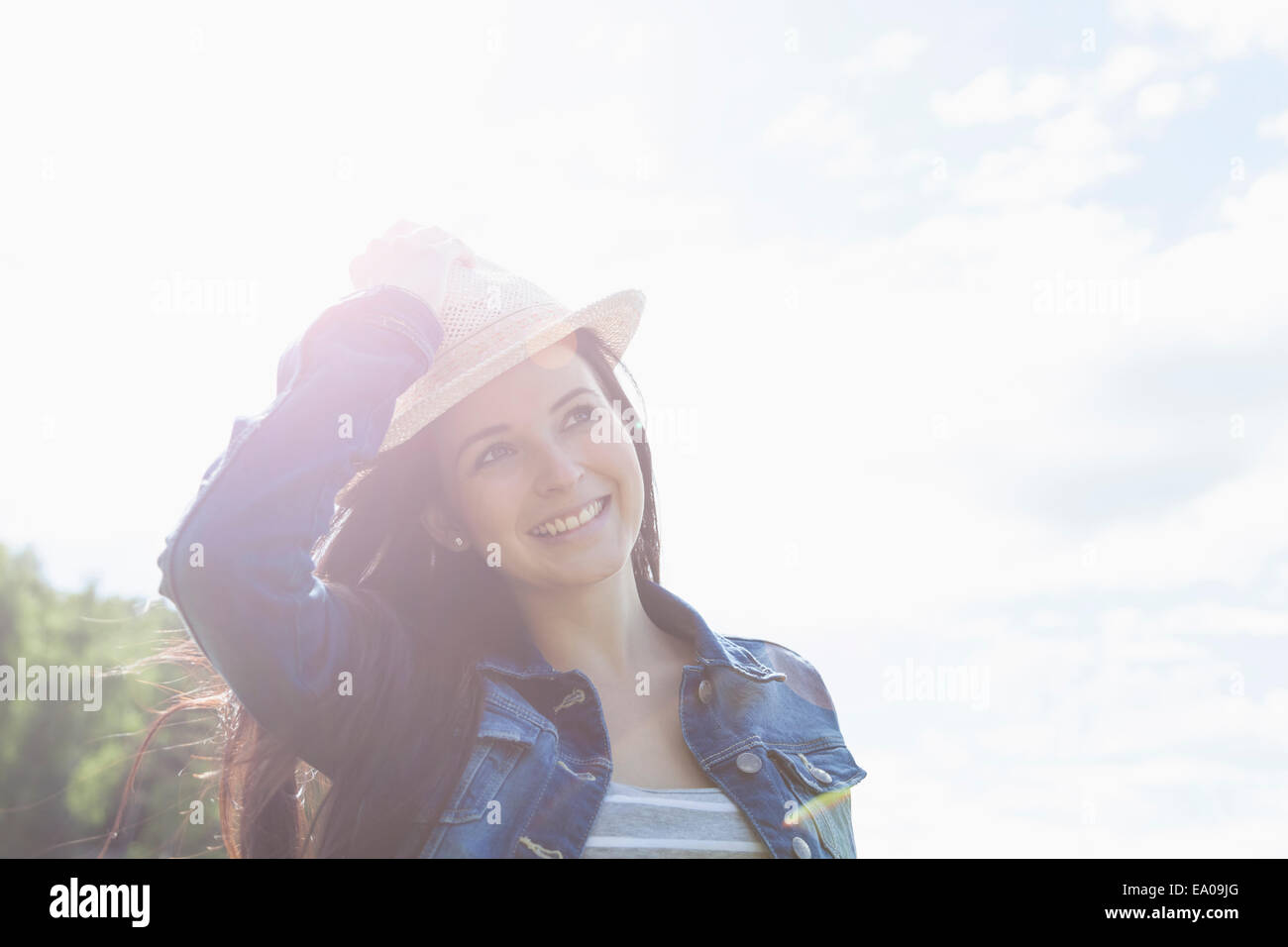 Mujer joven sonriente, reteniendo hat Foto de stock