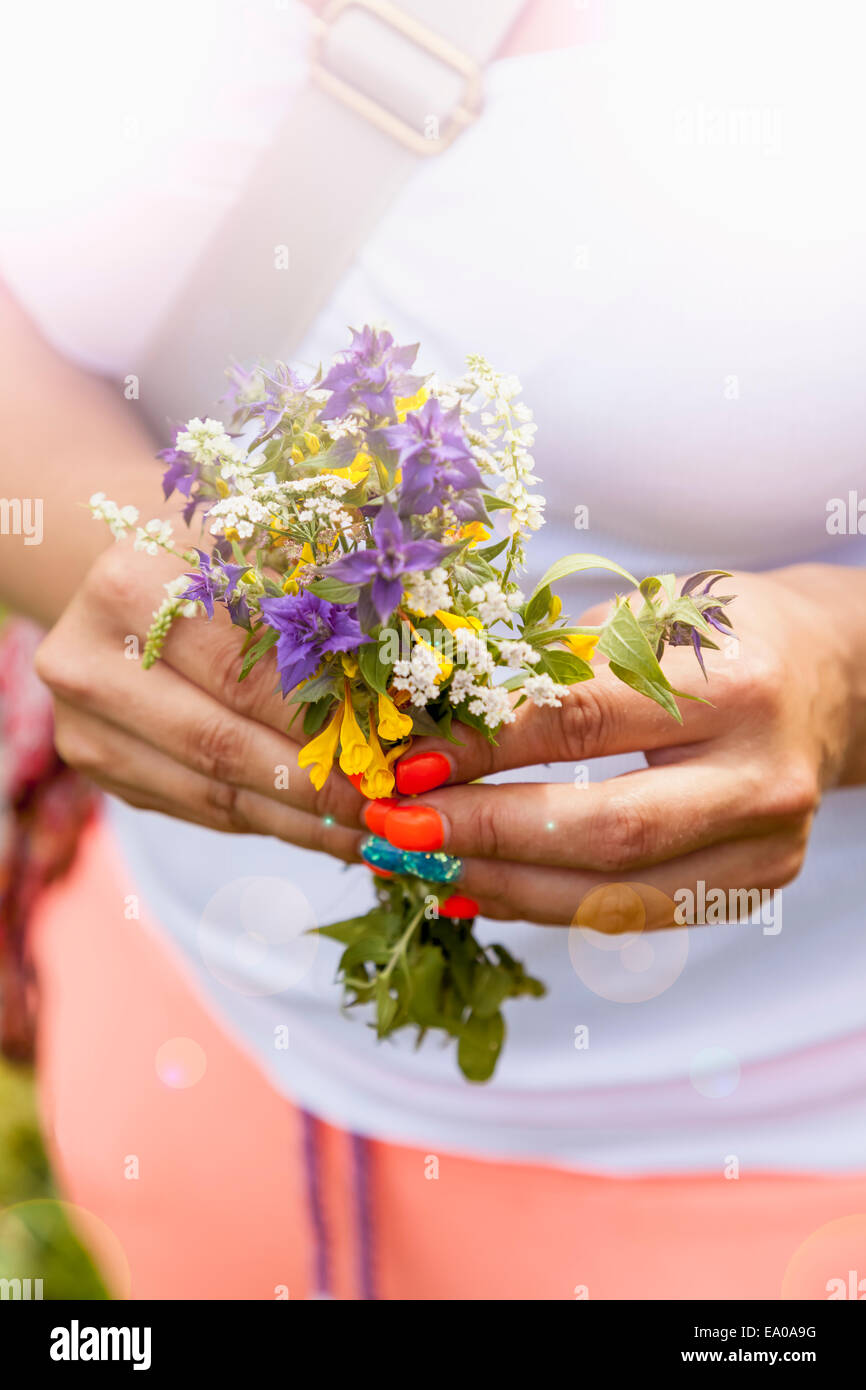 Mujer joven sosteniendo ramo de flores silvestres Foto de stock