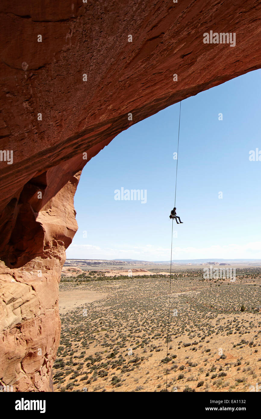 Mujer rappel desde arch, Moab, Utah, EE.UU. Foto de stock