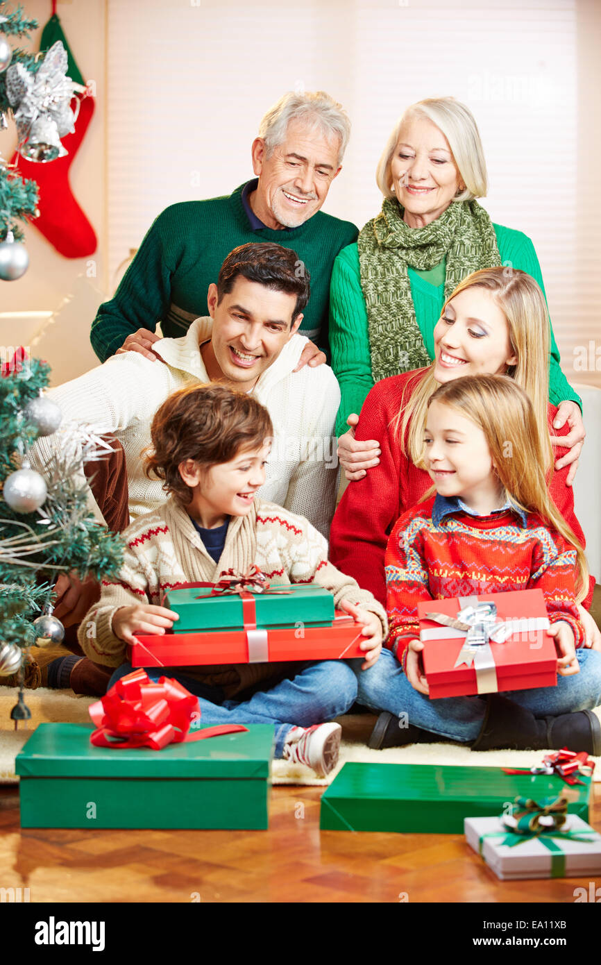 Con tres generaciones de la familia feliz celebrando la Navidad con regalos Foto de stock