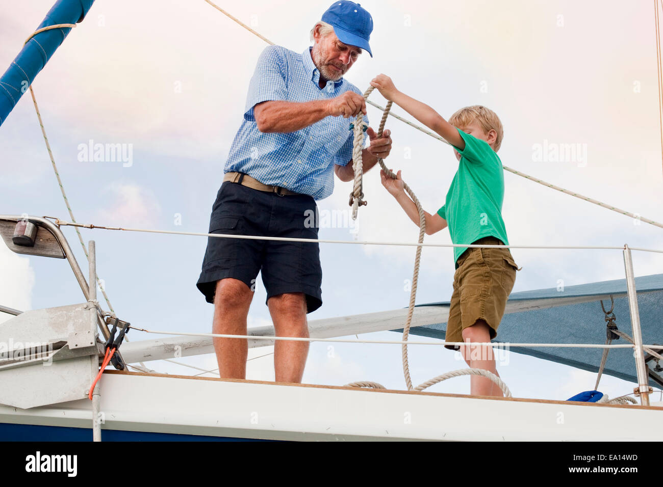 Chico y abuelo cuerda atado en velero Foto de stock