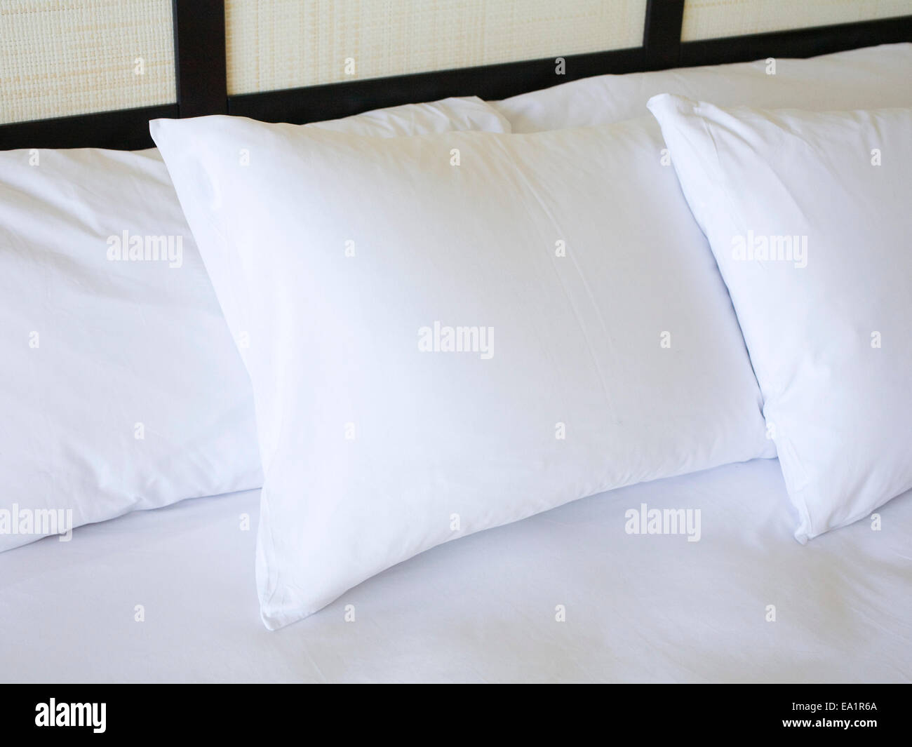 Blancas mullidas almohadas en la cama Foto de stock