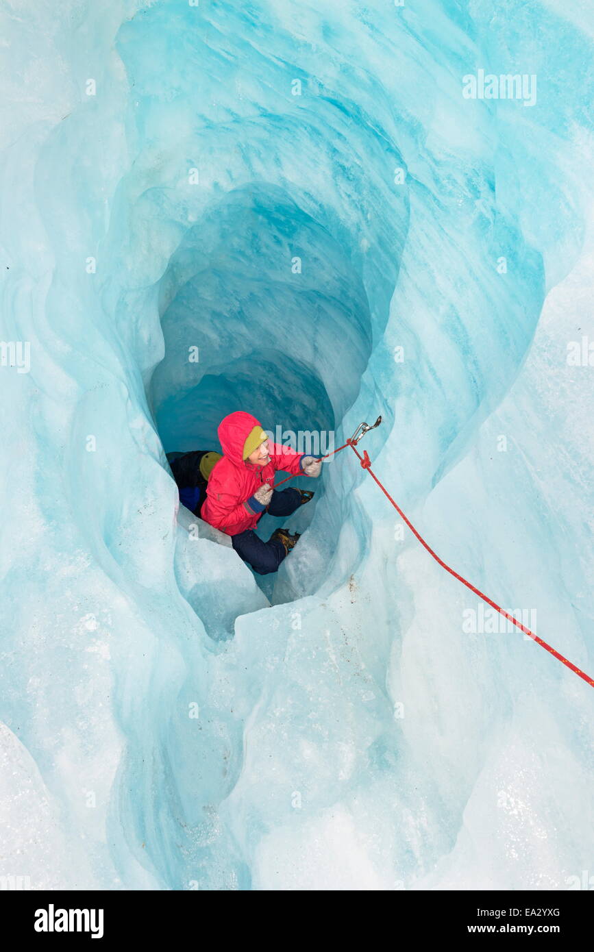 Escalador sube la cueva de hielo, el glaciar Fox, Isla del Sur, Nueva Zelanda, el Pacífico Foto de stock