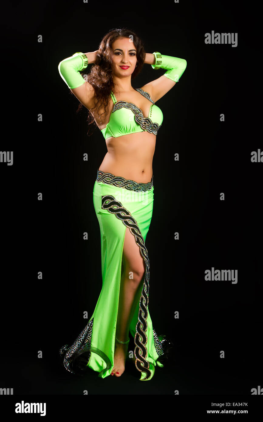 Hermosa joven morena en un traje verde de la danza oriental sobre fondo  negro Fotografía de stock - Alamy