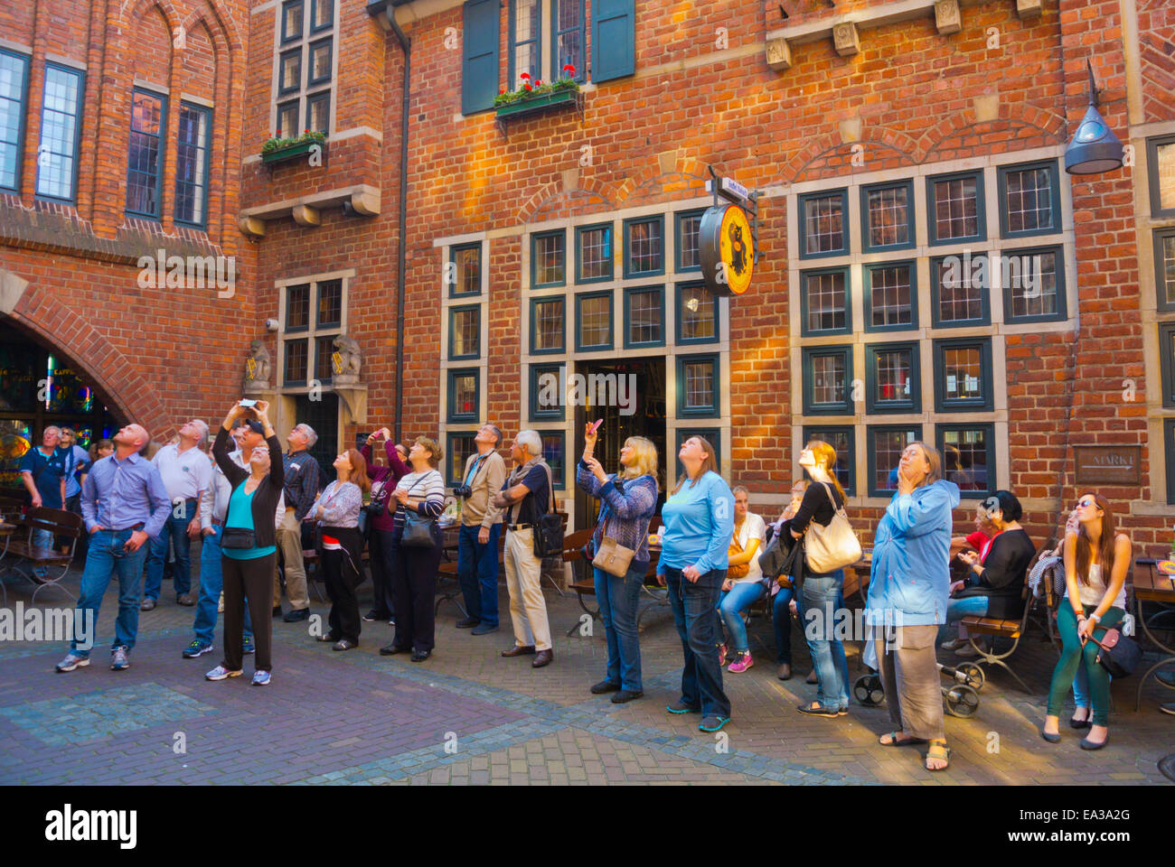 Viendo a la gente pasar Glockenspiel el reloj, la calle Böttcherstrasse, el Altstadt, el casco antiguo, Bremen, Alemania Foto de stock