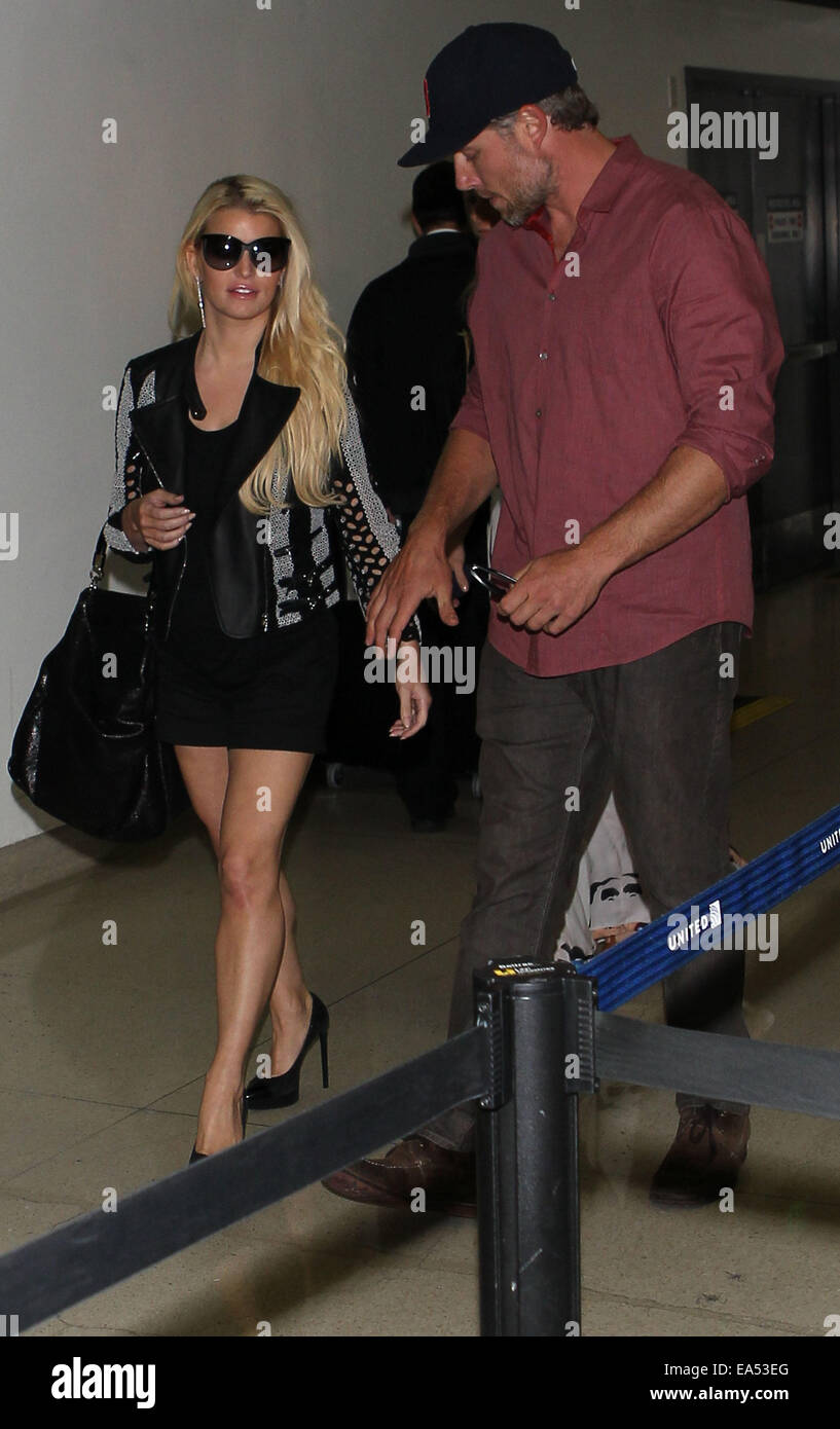 Jessica Simpson en breve falda negra y chaqueta de cuero, llega al  Aeropuerto Internacional de Los Ángeles (LAX) tomados de la mano con con su  pareja Eric Johnson con: Jessica Simpson,Eric Johnson