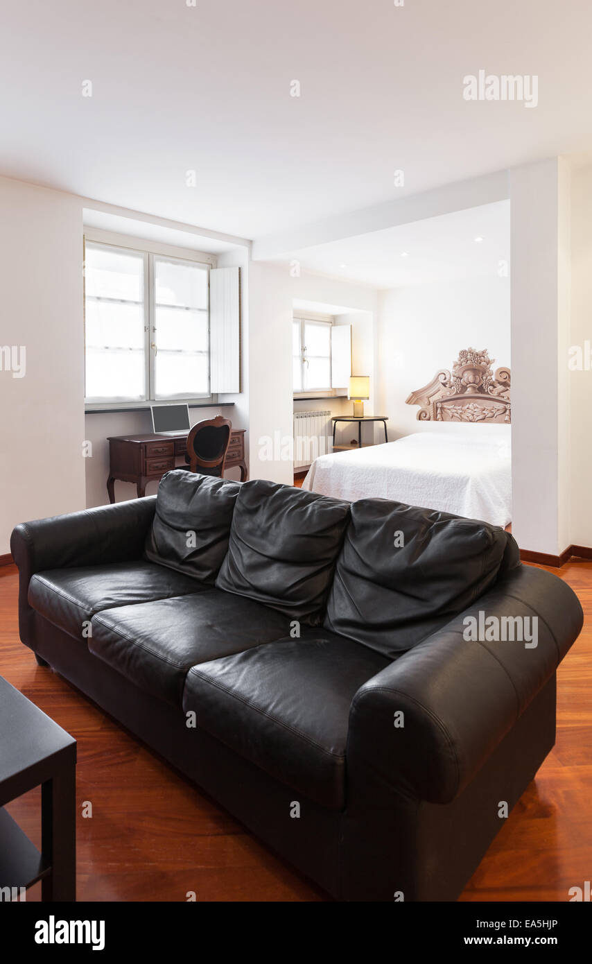 Bonito apartamento, interior, diván negro Foto de stock