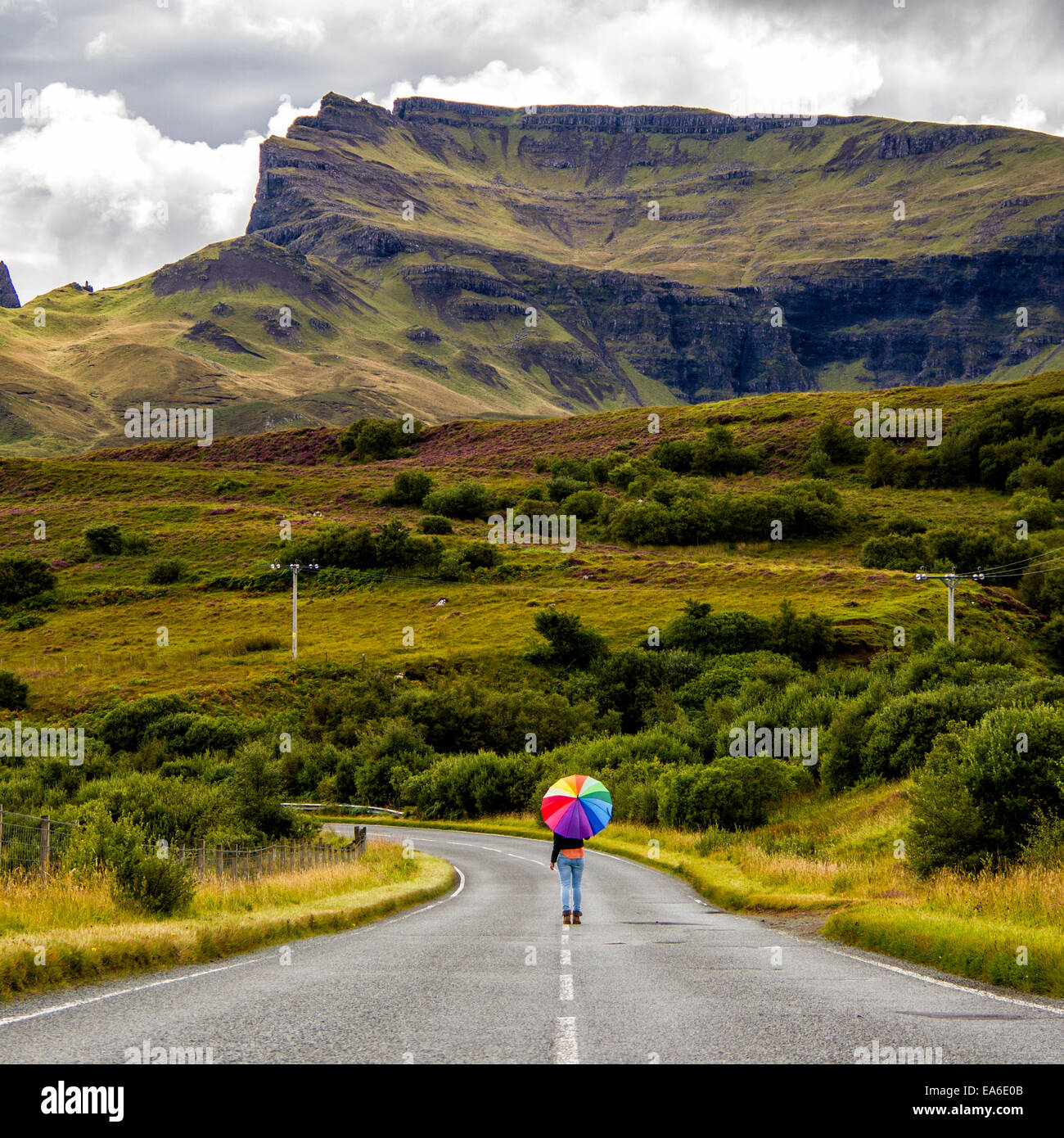 Reino Unido, Escocia, Mujer con sombrilla en Country Road Foto de stock