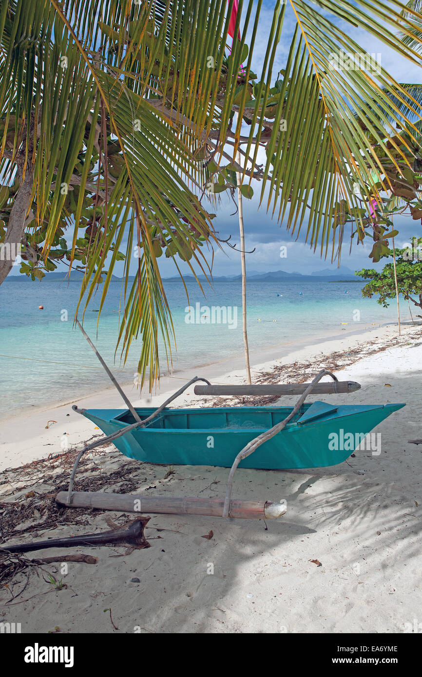 Pontoon Boat azul se encuentra sobre la playa de arena blanca en la isla de Pandan, Palawan, Filipinas, una atracción turística popular lugar de vacaciones. Foto de stock
