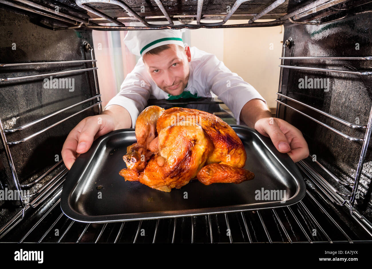 Chef prepara pollo asado (focus) en pollos en el horno, vista desde el  interior de la estufa. La cocción en el horno Fotografía de stock - Alamy