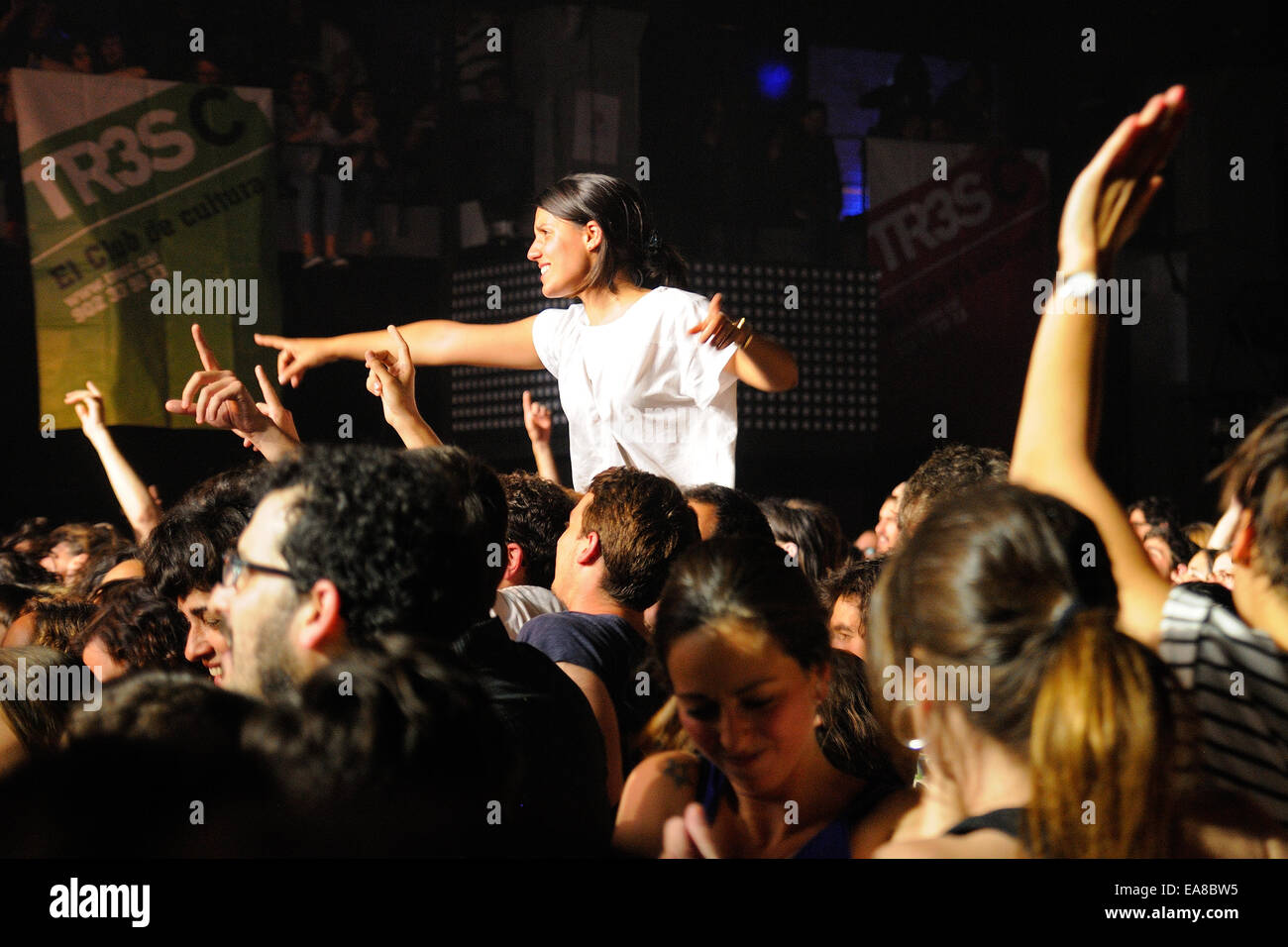 BARCELONA - 16 de mayo: una niña se levanta sobre la multitud en un concierto en la discoteca Razzmatazz el 16 de mayo de 2014 en Barcelona, España. Foto de stock