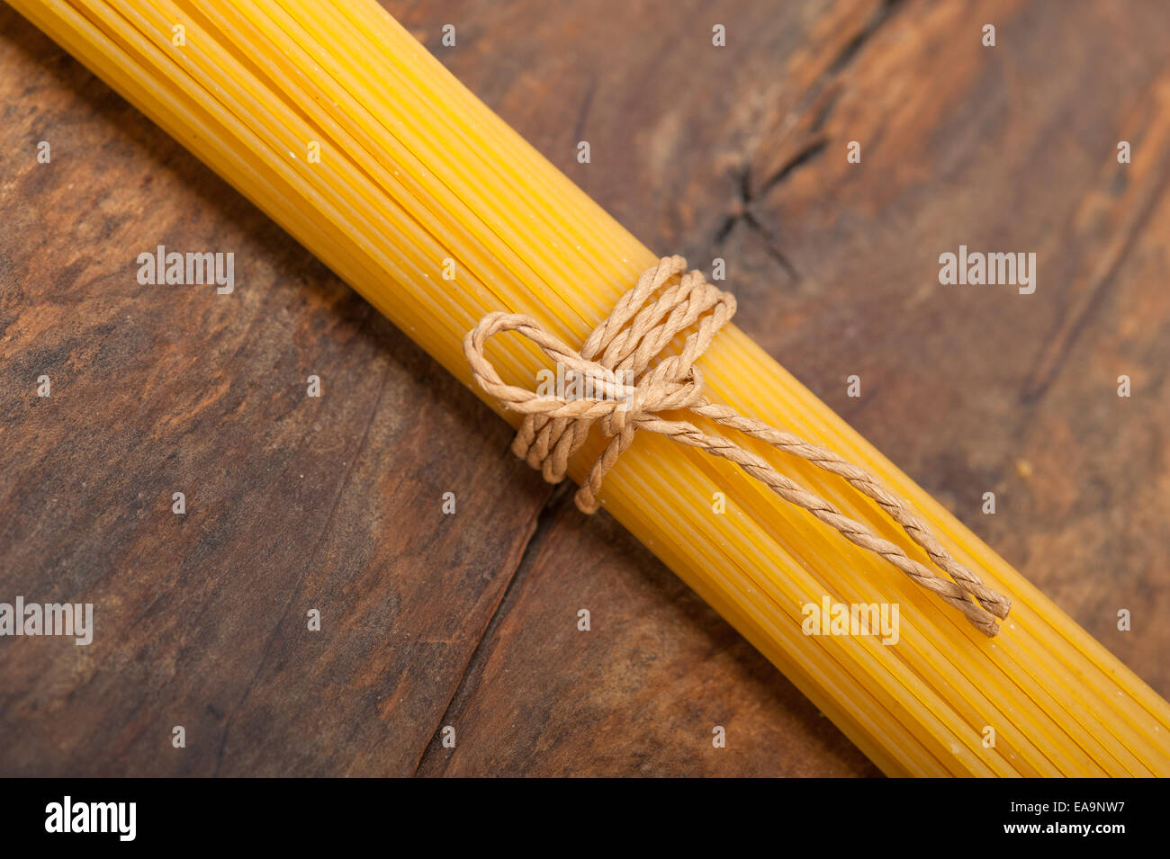 Las pastas italianas espaguetis atados con una cuerda en una tabla rústica Foto de stock