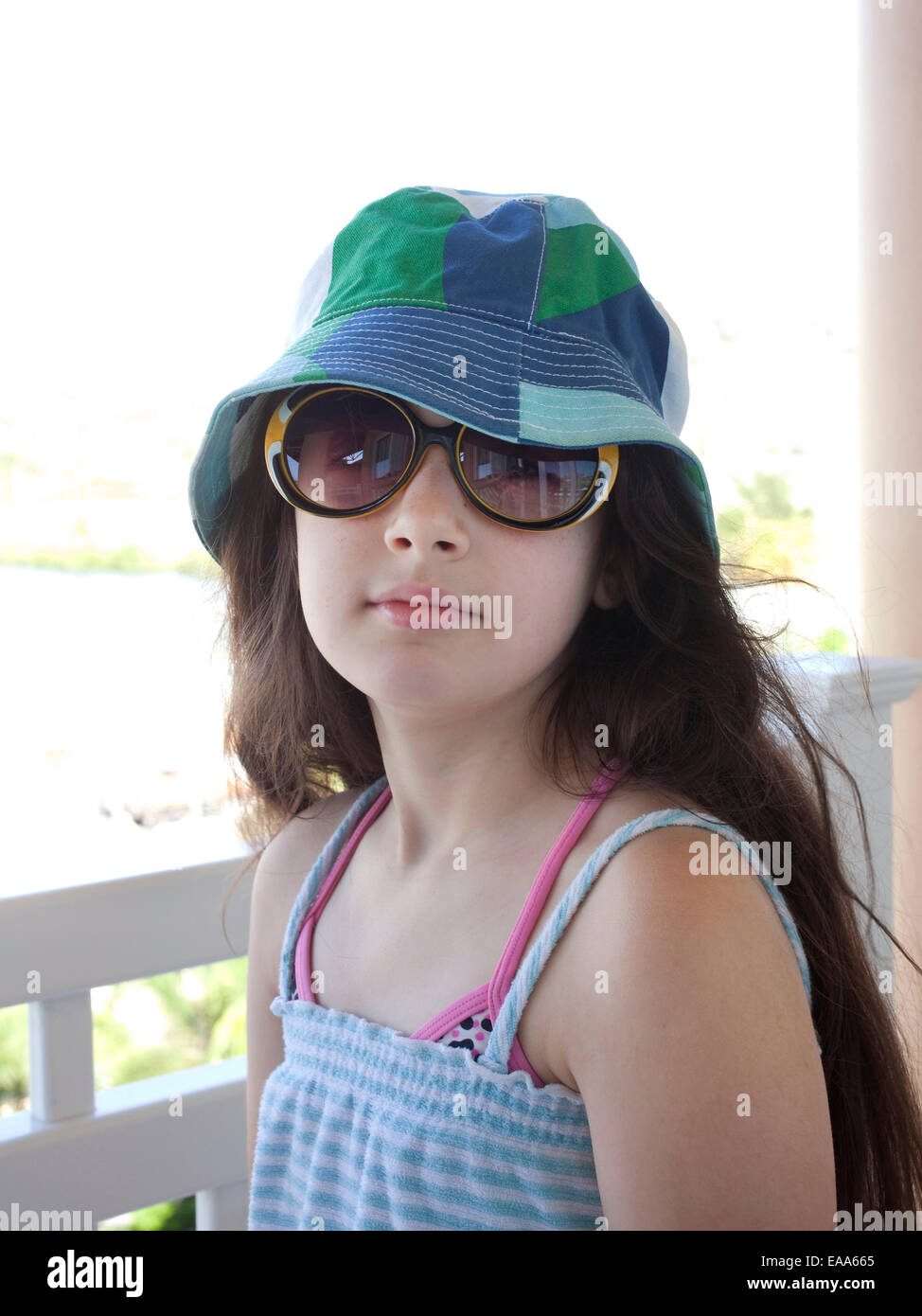 Chica en vacaciones de playa vistiendo gorra y gafas de sol Foto de stock